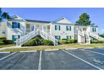 Beautiful condo featuring classic white siding, green shutters and access stairs at 4935 Crab Pond Ct. # 203, Myrtle Beach, SC 29579