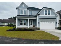 Charming two-story home with a well-manicured lawn, a two-car garage, and a covered front porch at 641 Waterbridge Blvd., Myrtle Beach, SC 29579
