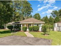 Charming single-story home featuring a well-maintained lawn, mature trees, and welcoming curb appeal at 6512 Laguna Point, Myrtle Beach, SC 29588