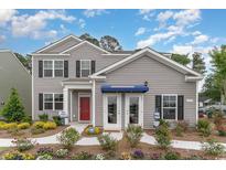 Charming two-story home with landscaped yard and a welcoming red front door at 692 Wallace Dr., Little River, SC 29566