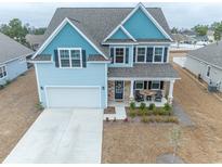 Charming two-story home with blue accents, a two-car garage, and a welcoming front porch at 860 Saluda River Rd., Myrtle Beach, SC 29588