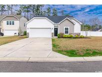 Charming one-story home featuring a two-car garage, white siding, a well-maintained yard, and a concrete driveway at 92 Costa Ct., Pawleys Island, SC 29585