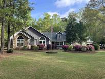 Charming home featuring stone accents, beautiful landscaping, and a welcoming front yard at 1 Sun Ct., Carolina Shores, NC 28467