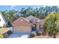 Charming brick home featuring an attached two-car garage and mature landscaping, including a palm tree at 110 Summerlight Dr., Murrells Inlet, SC 29576