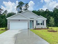 Charming single-story home with gray siding, well-manicured lawn, and a two-car attached garage at 1438 Porchfield Dr., Conway, SC 29526