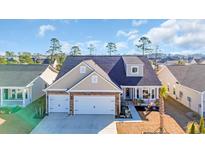 Beautiful two-story home with attached two-car garage, brick accents, and a well-manicured lawn at 166 New Paradise Way, Myrtle Beach, SC 29588