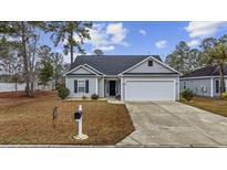 Charming one-story home featuring a well-maintained front yard with a paved driveway and attached garage at 175 Ecum Secum Pl., Conway, SC 29527