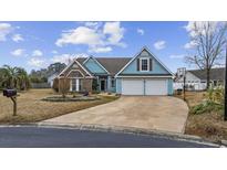 Charming blue two-story home with a well-manicured front yard and attached two-car garage at 3905 Thornwood Ct., Myrtle Beach, SC 29588