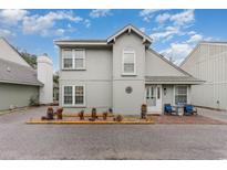 Two-story gray home with a pair of chairs and a 'Beach' sign on the brick patio at 717 41St Ave. S, North Myrtle Beach, SC 29582