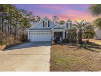 Charming blue two-story home with a well-manicured lawn and a spacious two-car garage at 920 Sewing Bee Pl., Little River, SC 29566