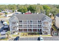 Three-story condo building featuring multiple units, balconies and outdoor staircase access with ample parking at 1058 Sea Mountain Hwy. # 202, North Myrtle Beach, SC 29582