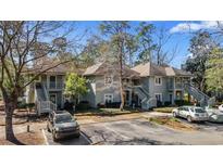 Inviting gray two-story condo complex featuring private entrances, stairs, and lush landscaping at 1221 Tidewater Dr. # 321, North Myrtle Beach, SC 29582