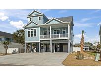 Inviting two-story home with light blue siding, white railings, and elevated design for beachside living at 128 Seabreeze Dr., Murrells Inlet, SC 29576