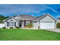 Charming single-story home featuring a manicured lawn and attached two-car garage at 130 Maiden Ln., Myrtle Beach, SC 29588