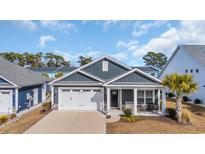 Charming single-Gathering home features a two-car garage, covered front porch, and manicured landscaping at 1317 Captain Hooks Way, North Myrtle Beach, SC 29582