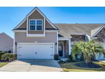 Charming home featuring stone accents, a two-car garage, and a well-maintained front lawn at 153A Parmelee Dr. # A, Murrells Inlet, SC 29576