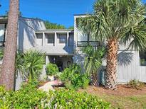 Charming two-story home with mature landscaping, including palms and flowering bushes at 219 Salt Marsh Circle # 14A, Pawleys Island, SC 29585