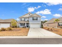 Charming two-story home with light blue siding and a well-manicured front yard on a sunny day at 235 Calhoun Falls Dr., Myrtle Beach, SC 29579