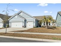 Charming single-Gathering home featuring a two-car garage, light blue siding, and well-manicured lawn at 2408 Blue Crane Circle, Myrtle Beach, SC 29577