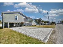 Charming raised beach home featuring a spacious paved driveway and covered parking at 308 24Th Ave. N, North Myrtle Beach, SC 29582