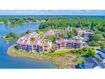 Beautiful aerial view of waterfront condos surrounded by lush greenery and serene lake waters at 501 Maison Dr. # F15, Myrtle Beach, SC 29572