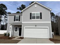 Two-story home featuring a two-car garage, gray siding, black shutters, and a well-manicured lawn at 536 Tillage Ct., Conway, SC 29526