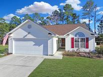 Charming single-story home with white siding, red shutters, attached garage, and well-manicured lawn at 6413 Sapling Ct., Myrtle Beach, SC 29588