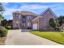 Charming brick home with a well-manicured lawn and inviting curb appeal on a sunny day at 6575 Sw Longwater Ct., Ocean Isle Beach, NC 28469