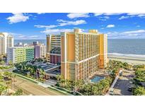 Beautiful, large, tan condo building next to the beach with palm trees and a pool at 6900 N Ocean Blvd. # 1139, Myrtle Beach, SC 29572