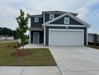 Charming two-story home with blue siding, white trim, and a large two car garage at 1001 Cavaletti Ct., Myrtle Beach, SC 29588