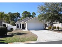 Charming single-story home with a well-manicured lawn and a two-car garage on a sunny day at 1077 Stoney Falls Blvd., Myrtle Beach, SC 29579