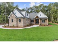 Beautiful brick home with manicured lawn, enhanced by a modern farmhouse design and inviting front entry at 1328 Foxtail Dr., Longs, SC 29568