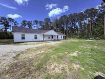 Charming single-story home featuring a bright exterior, a gravel drive and a well maintained lawn at 160 Leadwood St., Andrews, SC 29510