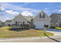 Charming single-story home with manicured landscaping, attached garage, and classic architectural details at 287 Whitchurch St., Murrells Inlet, SC 29576