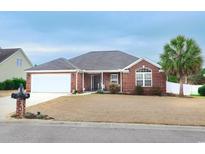 Charming brick home featuring an attached two-car garage and a well-manicured lawn at 304 Canyon Dr., Conway, SC 29526
