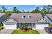 Charming duplex featuring well-manicured lawn, two-car garages, and inviting front porches in a lush, wooded community at 662 Sunnyside Dr. # 101, Murrells Inlet, SC 29576
