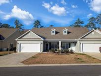 Charming single-story home featuring a two-car garage, well-kept lawn, and attractive architectural details at 662 Sunnyside Dr. # 101, Murrells Inlet, SC 29576