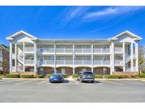 Three-story condo building with balconies, parking lot, and well-maintained landscaping at 670 Riverwalk Dr. # 304, Myrtle Beach, SC 29579