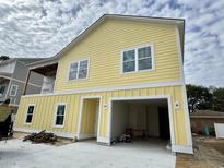 Bright yellow two-story home features an attached two-car garage and white trim at 713 9Th Ave. S, North Myrtle Beach, SC 29582