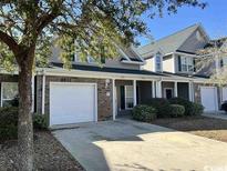 Two-story home boasts an attached garage, gray siding, and a manicured lawn at 722 Painted Bunting Dr. # C, Murrells Inlet, SC 29576