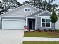 Charming single Gathering home showcasing manicured lawn, blue siding and a convenient two-car garage at 8639 Farrier Dr., Myrtle Beach, SC 29588