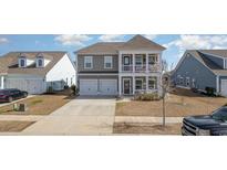 Charming two-story home featuring a double front porch, neutral siding, and an attached two-car garage at 985 Mourning Dove Dr., Myrtle Beach, SC 29577