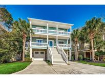 Two-story coastal home with dual balconies, palm trees, and driveway at 1006 Clubhouse Dr., North Myrtle Beach, SC 29582