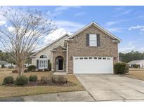 Charming brick home with manicured lawn and two-car garage on a sunny day at 1024 Dizzy Ct., Surfside Beach, SC 29575