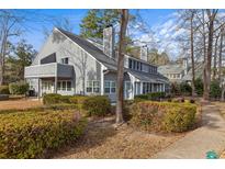 Charming gray two-story townhome exterior featuring mature landscaping, a private balcony, and driveway at 1205 Erin Way # 5C, Myrtle Beach, SC 29577