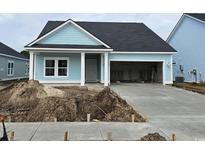 Charming single-story home with light blue siding and a spacious two-car garage, landscaped for curb appeal at 1604 Seachase Way, North Myrtle Beach, SC 29582