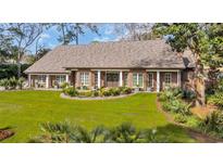 Charming brick home featuring well-manicured lawn, meticulous landscaping, and a welcoming entrance with stylish decor at 1616 Hawthorn Dr., Pawleys Island, SC 29585