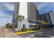 View of a large condo building with palm trees, signage, and parking area at 2001 S Ocean Blvd. # 418, Myrtle Beach, SC 29577