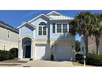 Charming two-story coastal home with a two-car garage, arched entryway and palm tree at 306 7Th Ave. S, North Myrtle Beach, SC 29582