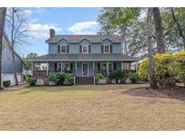 Charming two-story home featuring a welcoming front porch and nicely landscaped yard at 317 14Th Ave. N, Surfside Beach, SC 29575